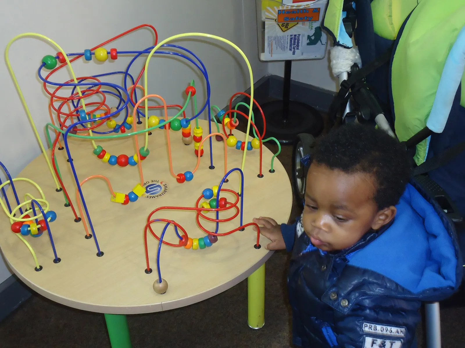 Child playing at the bead maze table toy