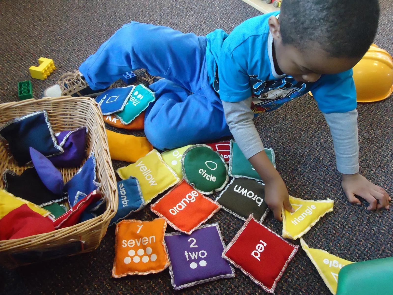 Child playing with soft number and shape bean bags