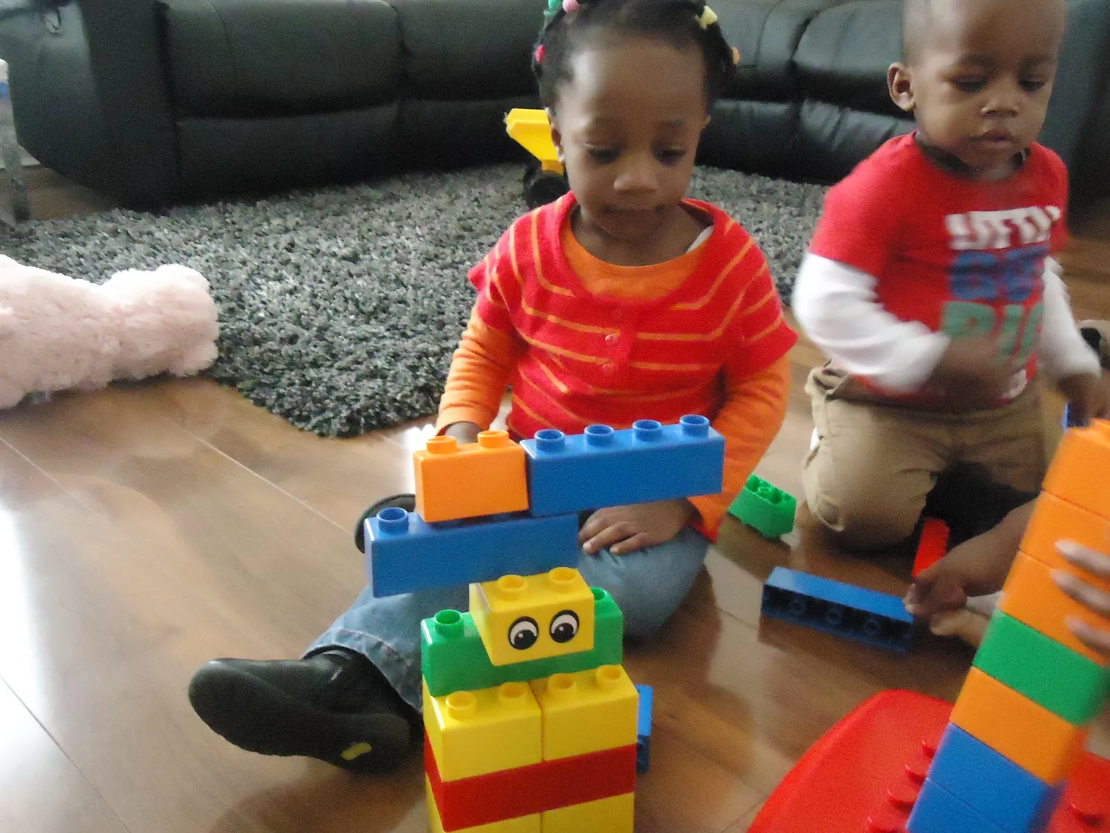 Two children building with large plastic blocks