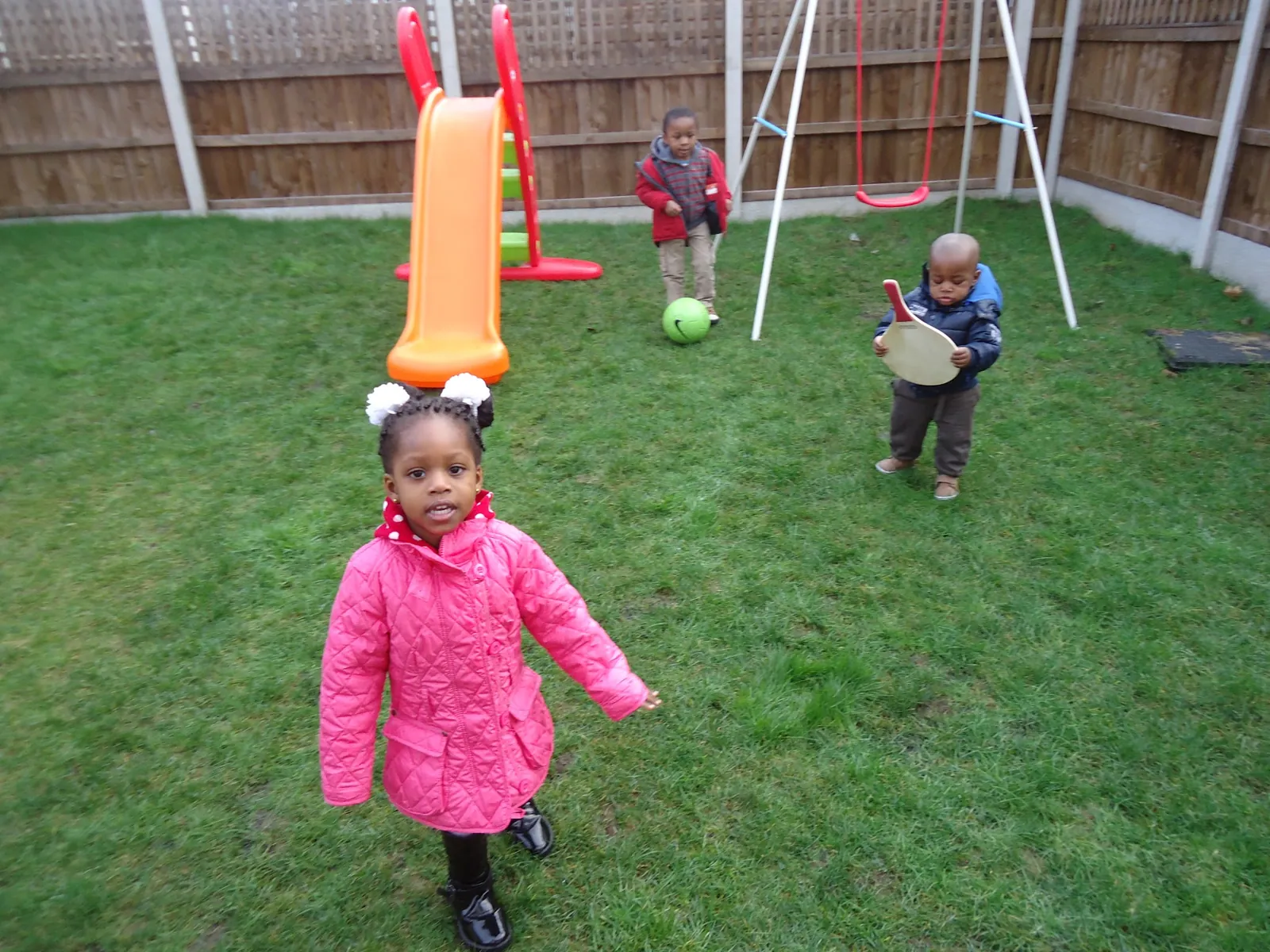 Children playing in the garden by the slide and swings