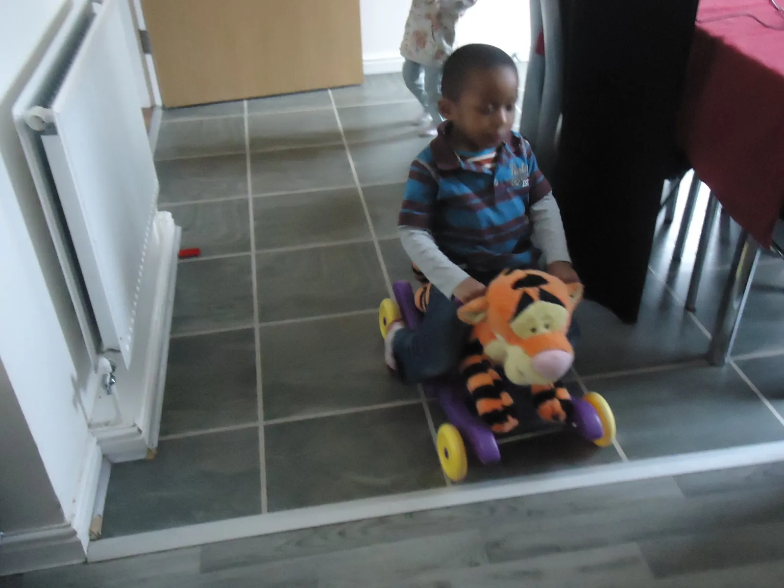 Toddler riding a ride-on toy indoors