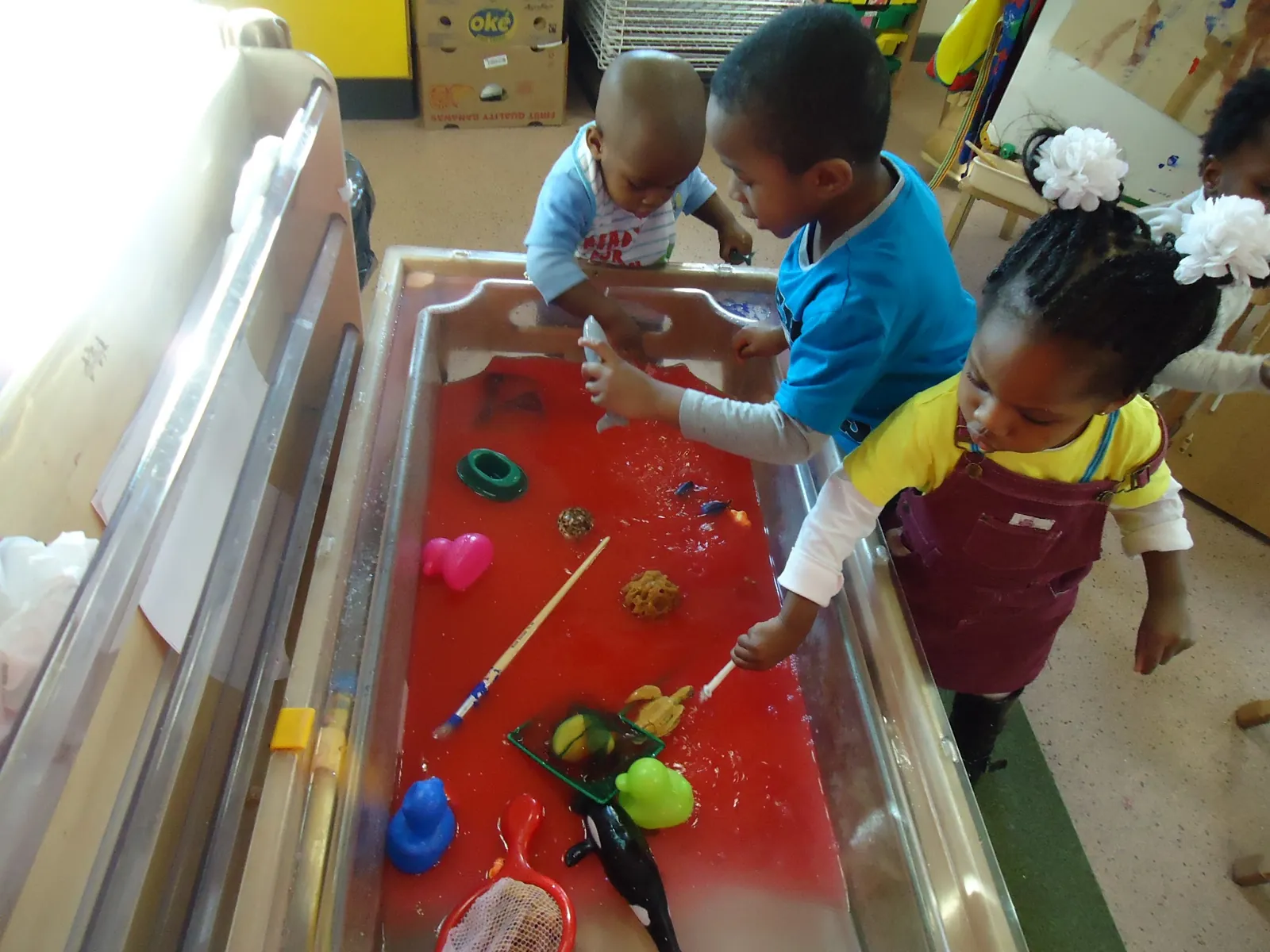 Children exploring toys in the water tray